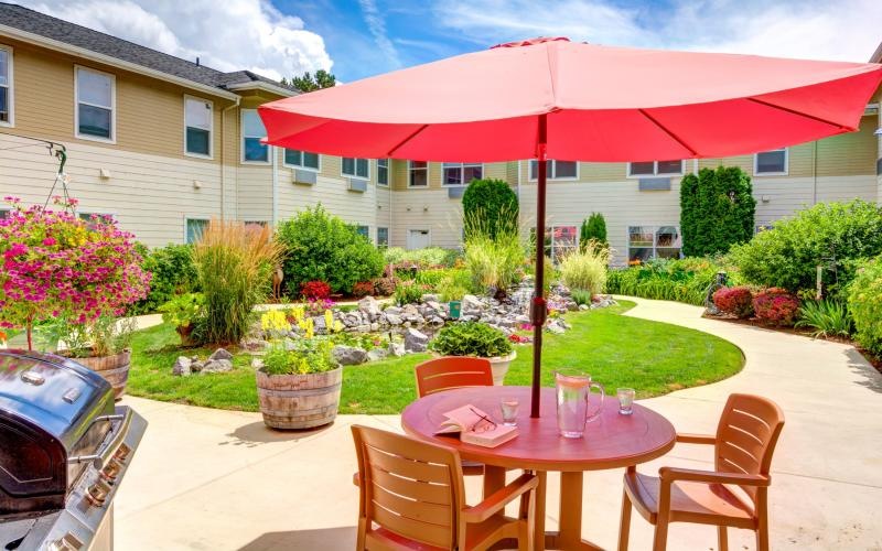 a patio with a table and chairs and umbrellas