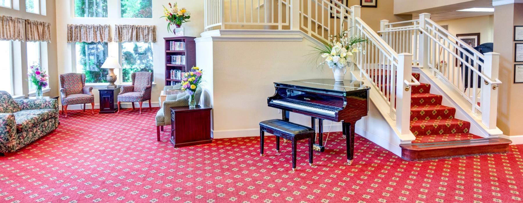 a large room with a piano and a staircase