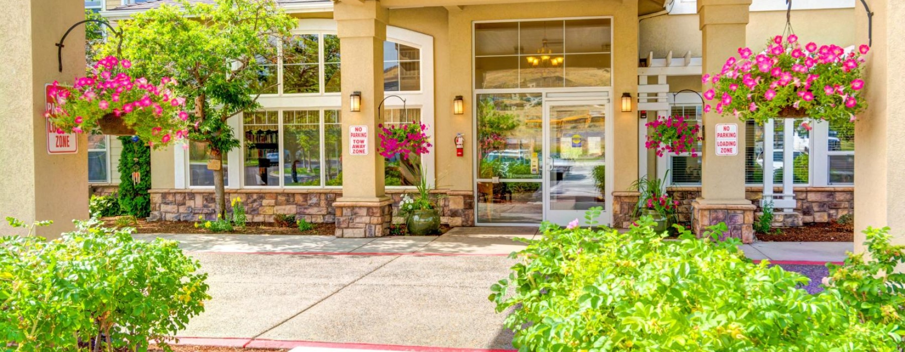 a building with a glass front door and a flower bed