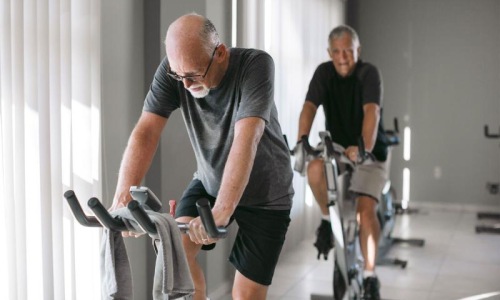 two men working out on a bicycle